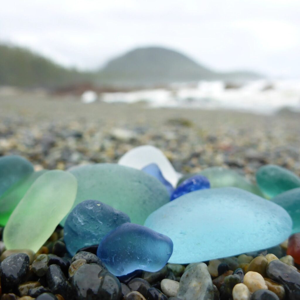 nested on a gravel beach is a day's collection of perfectly frosted dusty blue, green, and aqua seaglass